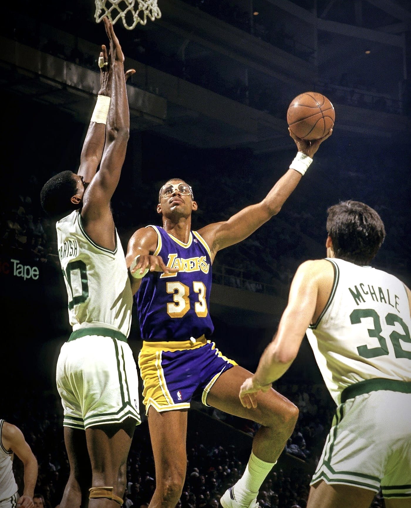 Kareem Abdul-Jabbar shooting over two Boston Celtics defenders in a Los Angeles Lakers number 33 jersey