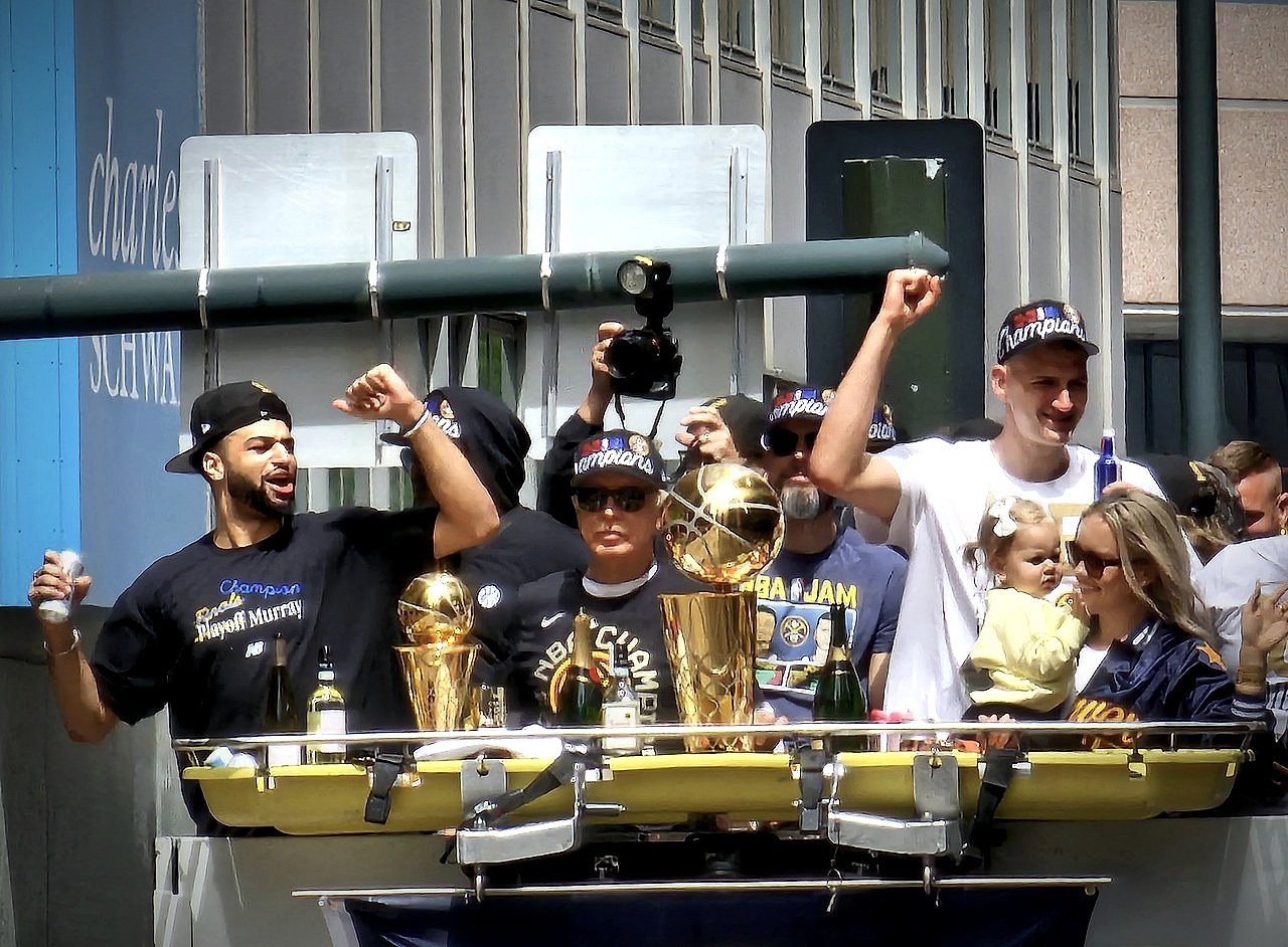 Nikola Jokic on the Denver Nuggets championship parade float in June 2023, with the Larry O'Brien trophy in front of him
