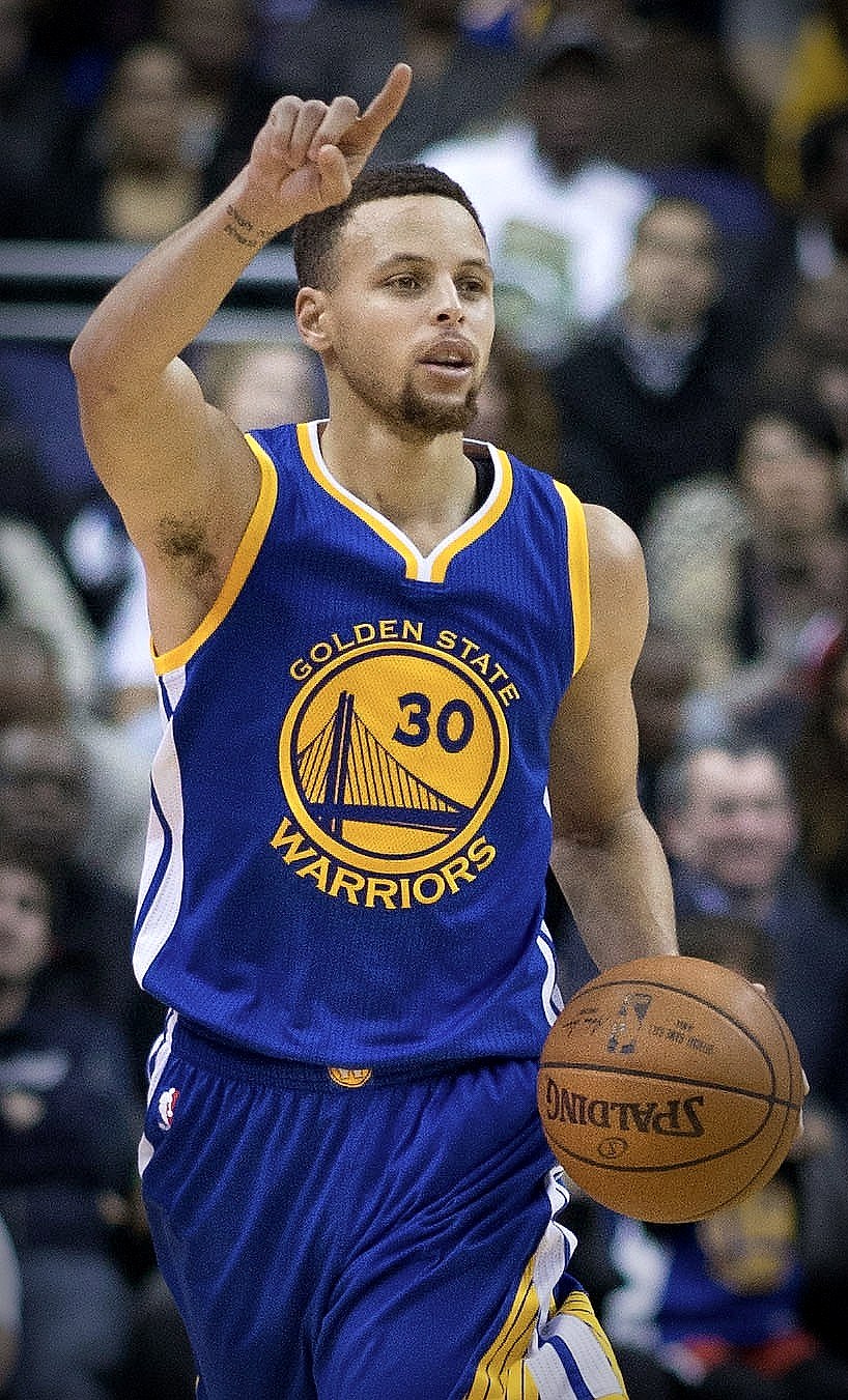 Stephen Curry in a Golden State Warriors number 30 jersey holding a basketball