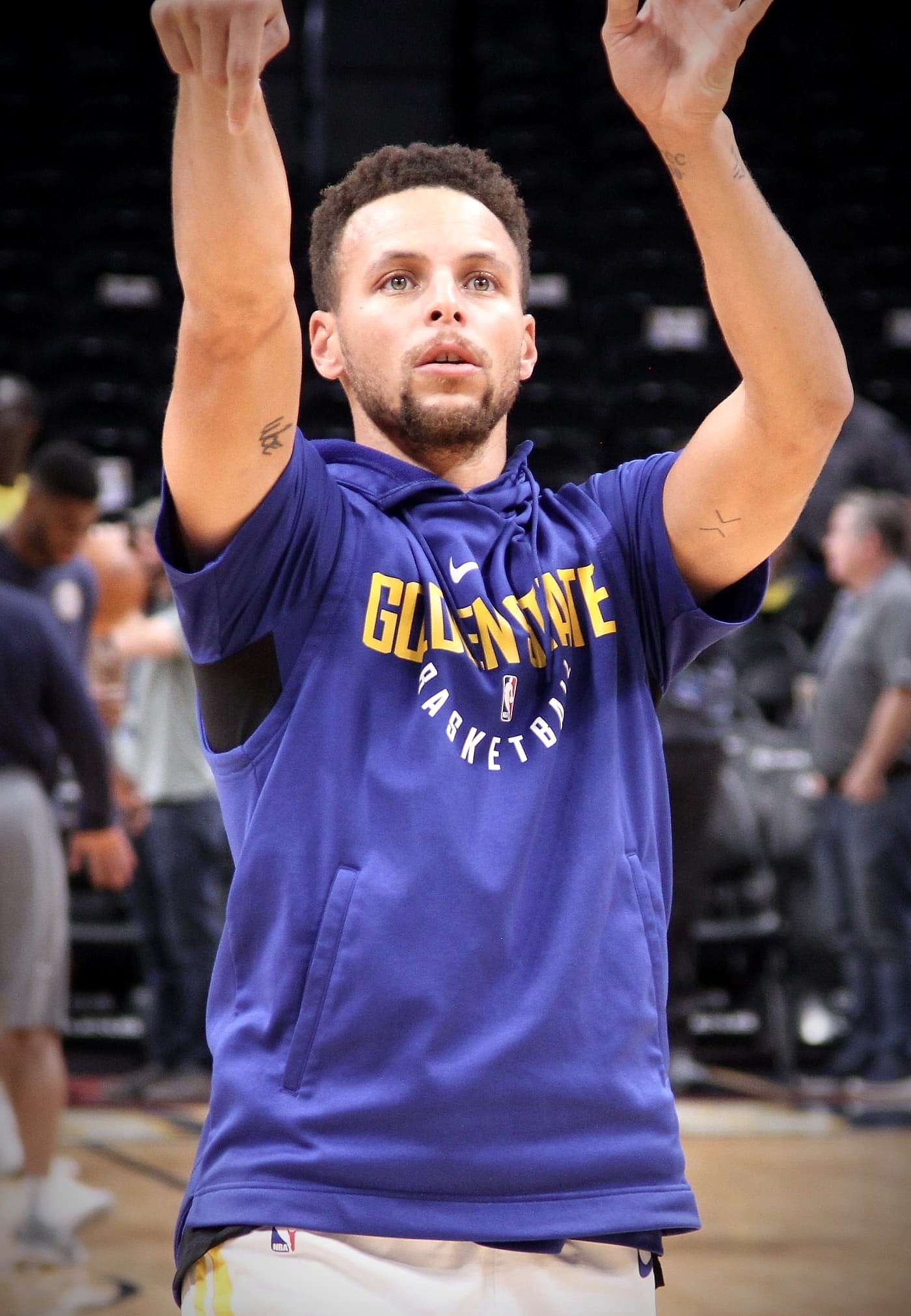 Stephen Curry follows through on a jump shot in Golden State Warriors warmup gear