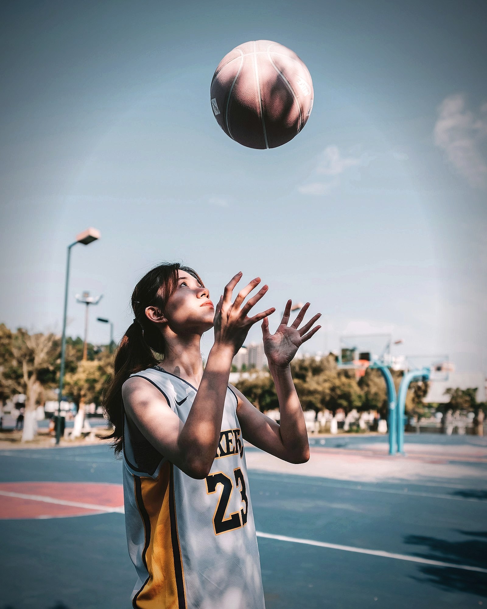 A basketball player reaching up to receive a pass mid-game
