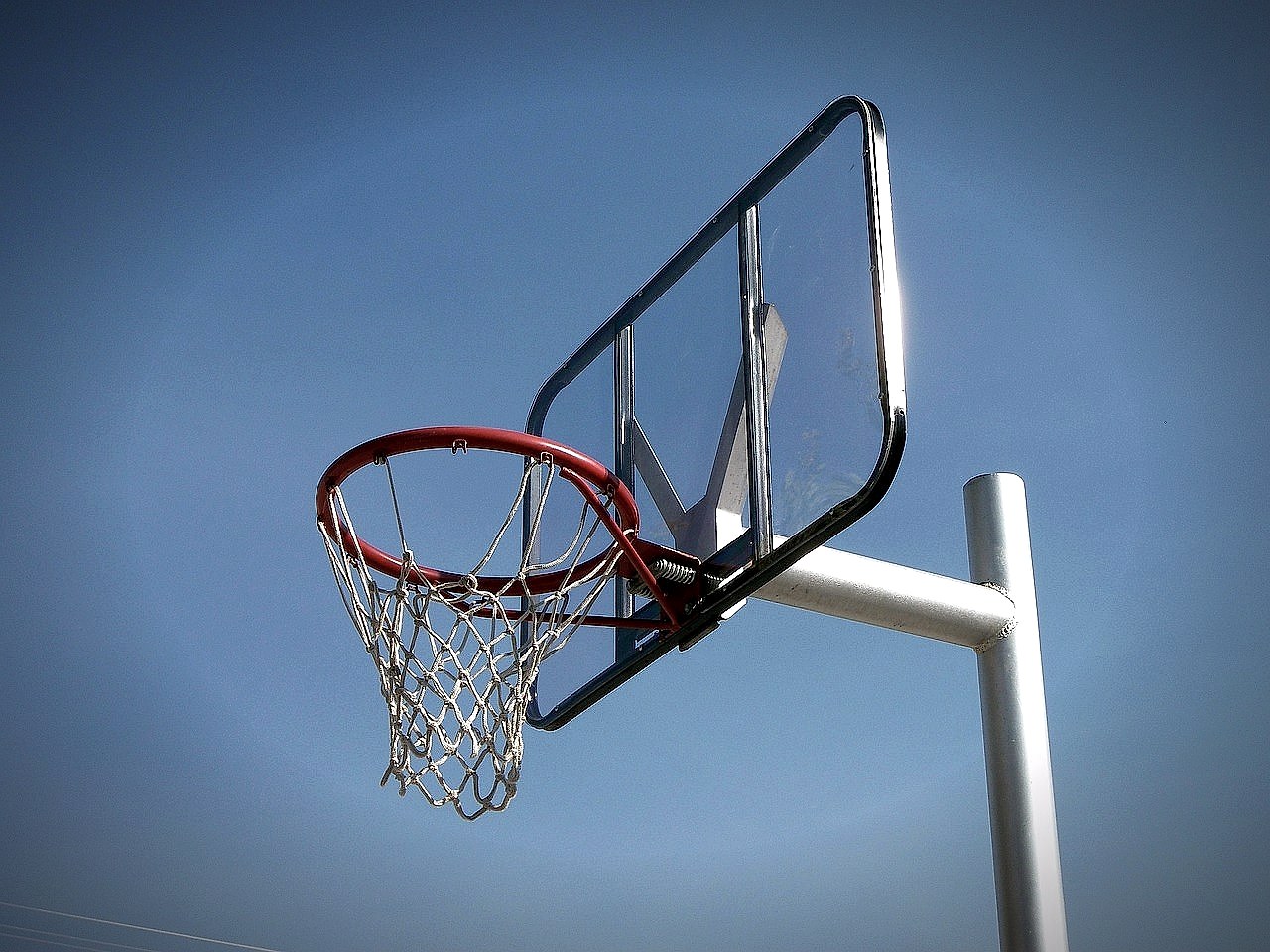 A basketball hoop and net against an outdoor backdrop