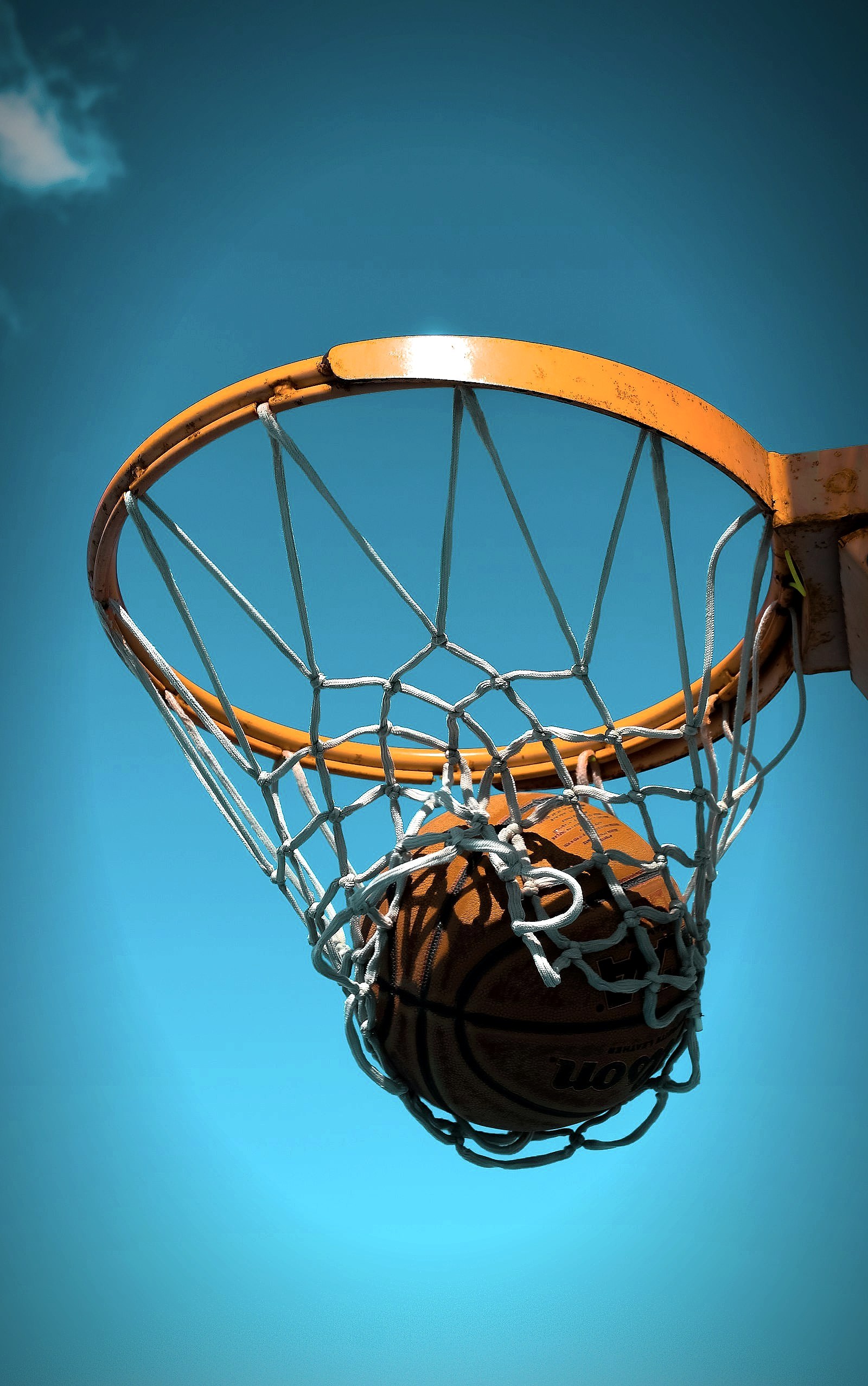 A basketball and hoop with net, close up