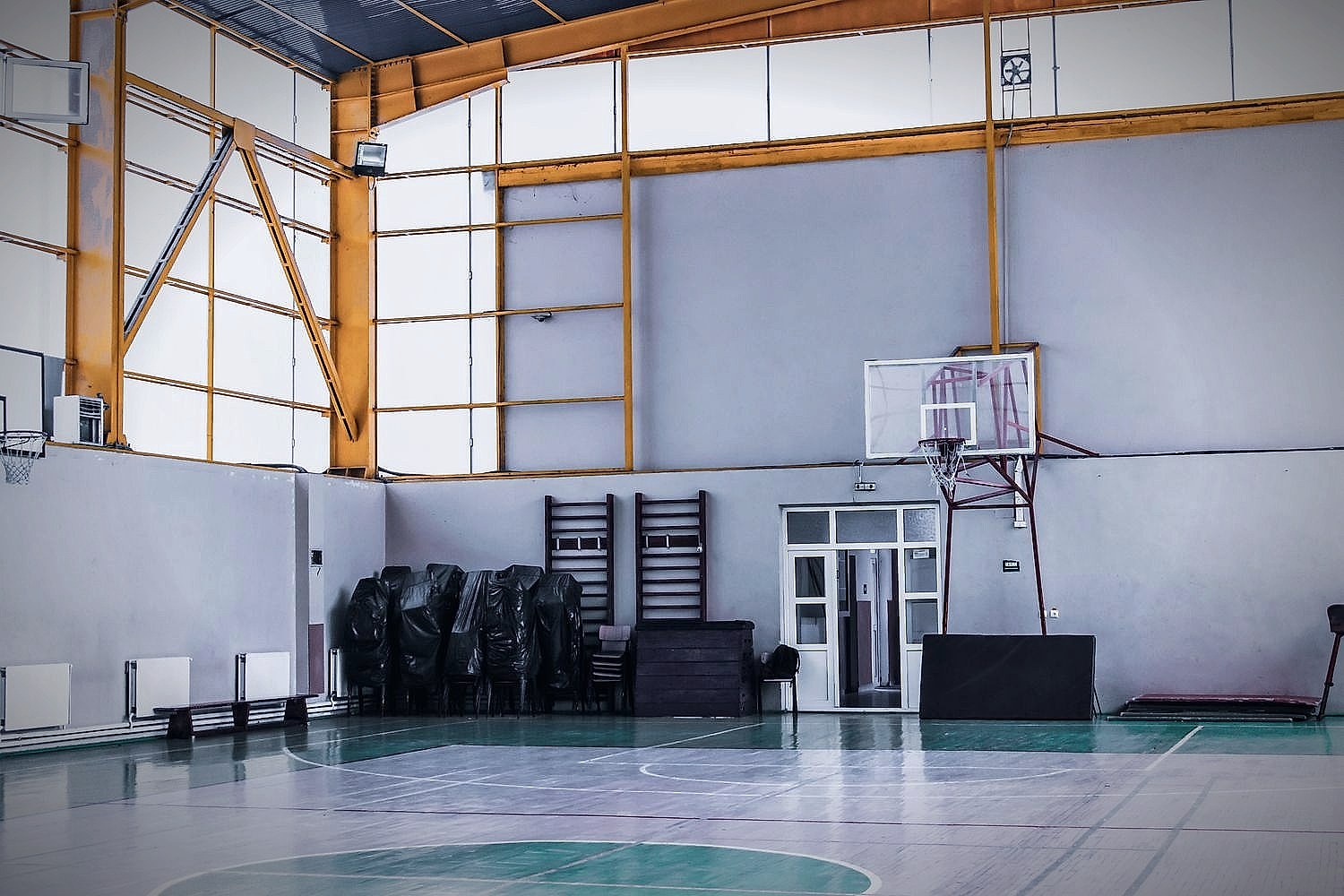 An indoor basketball court with hoops in a sports facility